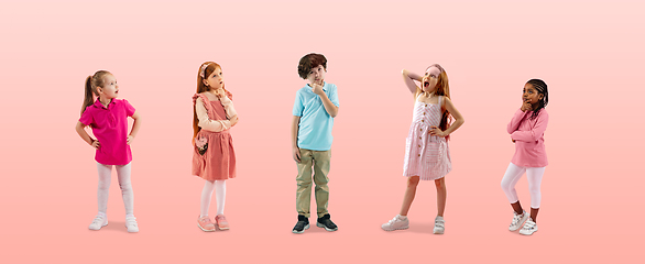 Image showing Group of elementary school kids or pupils in colorful casual clothes on pink studio background. Creative collage.