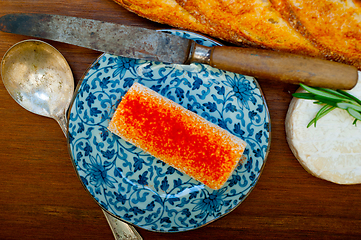 Image showing French cheese and fresh  baguette on a wood cutter