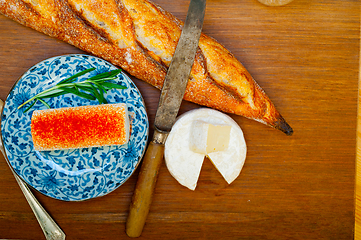 Image showing French cheese and fresh  baguette on a wood cutter