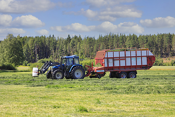 Image showing Collecting Freshly Cut Hay for Silage With Forage Wagon