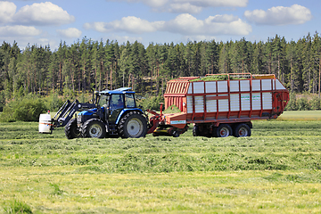 Image showing Collecting Cut Hay for Silage With Forage Wagon