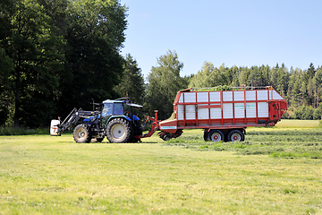 Image showing Tractor and Forage Trailer Collecting Hay for Silage