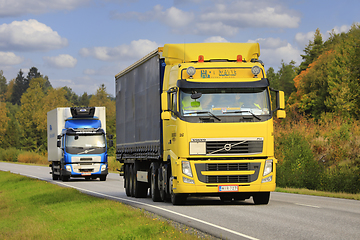 Image showing Yellow and Blue Volvo Trucks on the Road