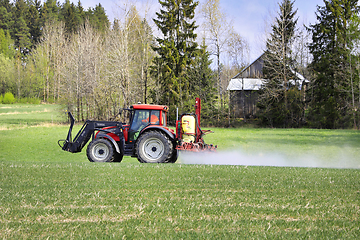 Image showing Tractor and Sprayer in Field in the Spring