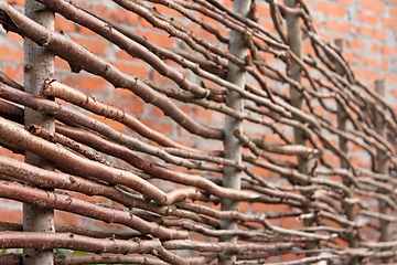 Image showing Wooden stylized horizontal fence and red brick wall as a defocus