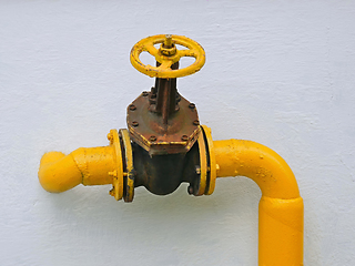 Image showing Old gas valve on the pipe goes into the vertical wall