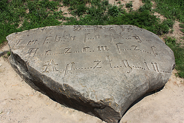 Image showing Encoded ancient engraved inscription by Gothic font with missing