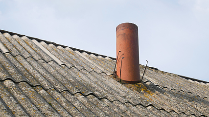 Image showing Chimney in the form of a pipe on the old slate roof of the barn,