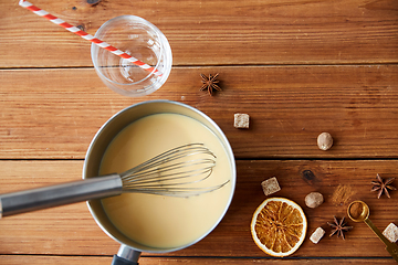 Image showing pot with eggnog, ingredients and spices on wood