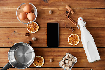 Image showing smartphone, ingredients for eggnog cooking