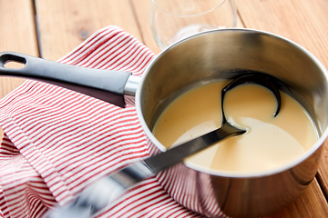 Image showing pot with eggnog and ladle on kitchen towel