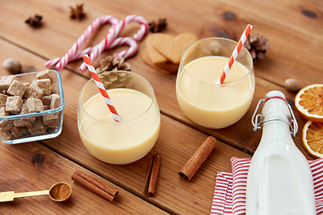 Image showing glasses of eggnog, ingredients and spices on wood