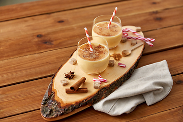 Image showing glasses of eggnog, ingredients and spices on wood
