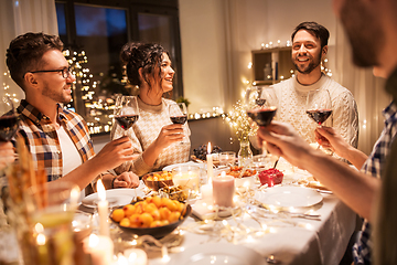 Image showing happy friends drinking red wine at christmas party