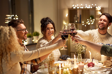 Image showing happy friends drinking red wine at christmas party