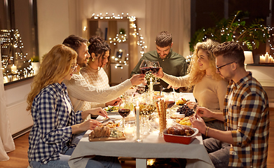 Image showing happy friends drinking red wine at christmas party