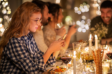 Image showing woman with smartphone at dinner party with friends