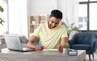 Image showing indian man with notebook and laptop at home office