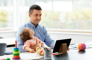 Image showing father with baby working on tablet pc at home