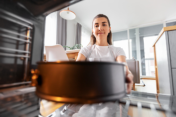 Image showing woman cooking food in oven at home kitchen