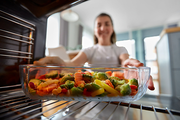 Image showing woman cooking food in oven at home kitchen