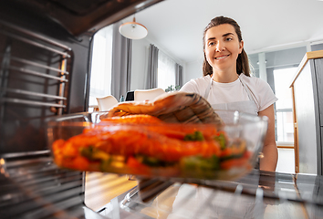 Image showing woman cooking food in oven at home kitchen