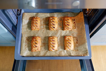 Image showing baking tray with jam pies in oven at home kitchen