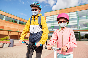 Image showing children in masks riding scooters over school