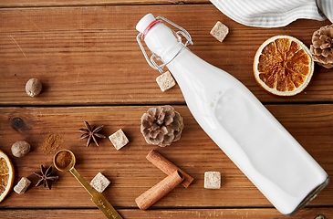 Image showing bottle of milk and spices and sugar on wood