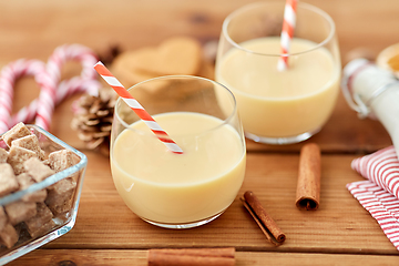 Image showing glasses of eggnog, ingredients and spices on wood