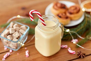 Image showing eggnog with candy cane in mug and cinnamon buns