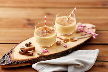 Image showing glasses of eggnog, ingredients and spices on wood