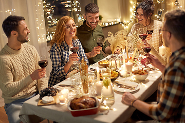 Image showing happy friends drinking red wine at christmas party