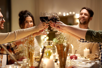 Image showing happy friends drinking red wine at christmas party