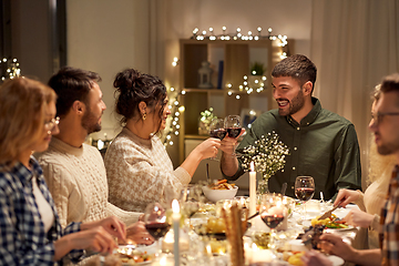 Image showing happy friends drinking red wine at christmas party