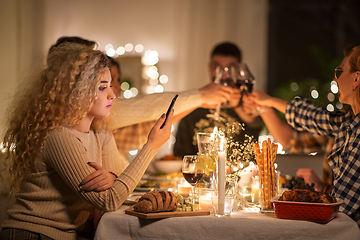 Image showing woman with smartphone at dinner party with friends