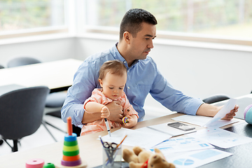 Image showing father with baby working at home office