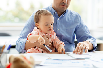 Image showing father with baby working at home office