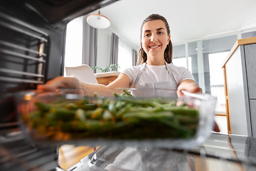 Image showing woman cooking food in oven at home kitchen