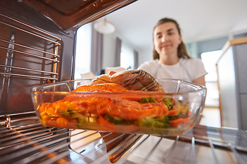 Image showing woman cooking food in oven at home kitchen