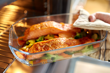 Image showing woman cooking food in oven at home kitchen