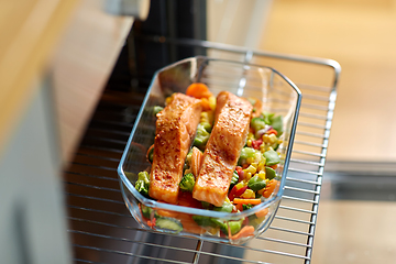 Image showing food cooking in baking dish in oven at home