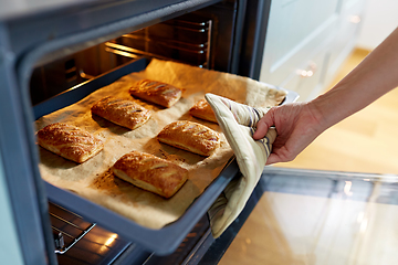 Image showing woman cooking food in oven at home kitchen