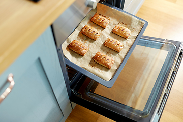 Image showing baking tray with jam pies in oven at home kitchen