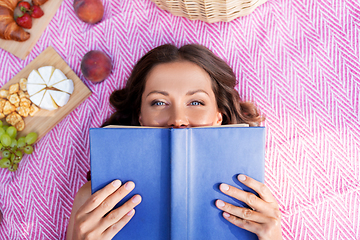 Image showing happy woman reading book at picnic in summer park