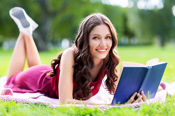 Image showing happy smiling woman reading book at summer park