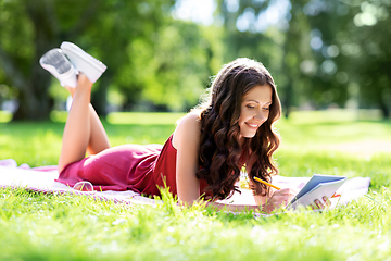 Image showing happy woman with diary or notebook at park