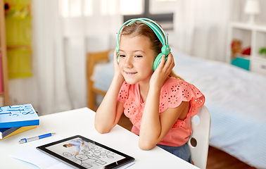 Image showing girl in headphones with tablet computer at home