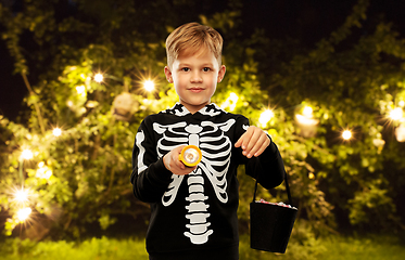 Image showing boy with candies and flashlight on halloween