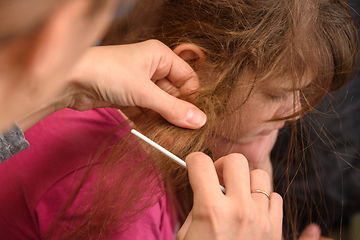 Image showing Mom tries to comb the girl's badly tangled hair